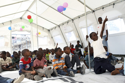 Crianças frequentam aula por meio do programa "School in a Box", uma série de escolas temporárias criadas pelo UNICEF e Cruz Vermelha dinamarquesa em campo de deslocados internos de Porto Príncipe, capital do Haiti. UN Photo/Sophia Paris